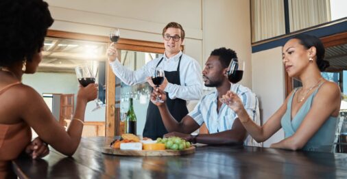 Wine tasting, friends and wine at a restaurant or vineyard learning of grape growth and production.