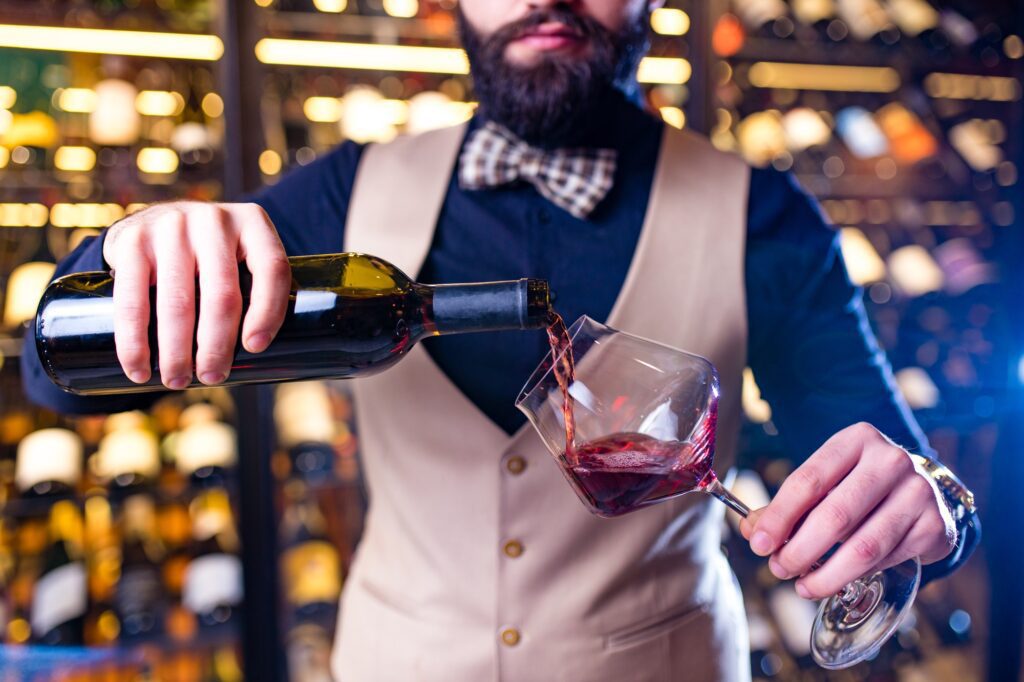 arabian man sommelier appreciating drink in lux hotel