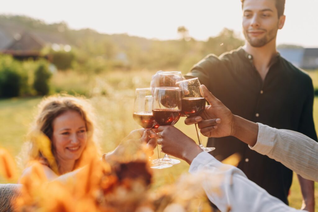 group of happy friends having fun outdoors at a farmhouse vineyard